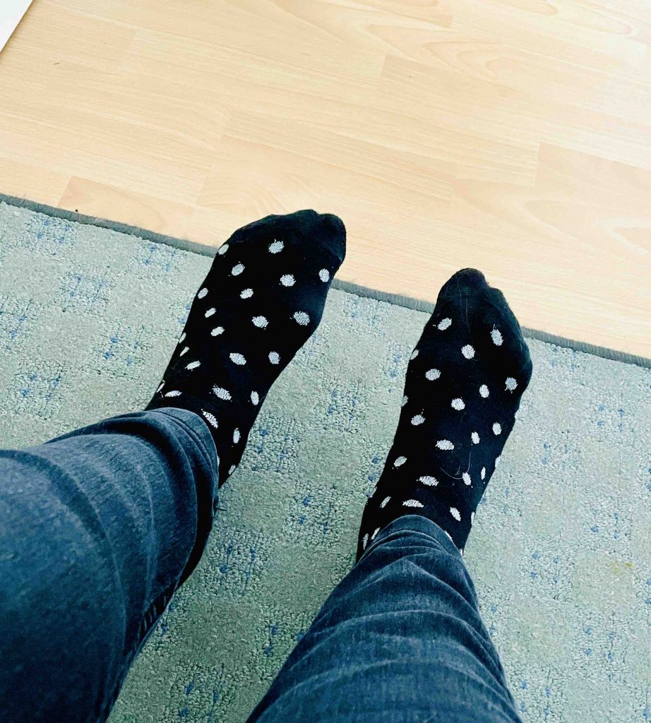Füße mit schwarzen Socken mit silbernen Punkten drauf